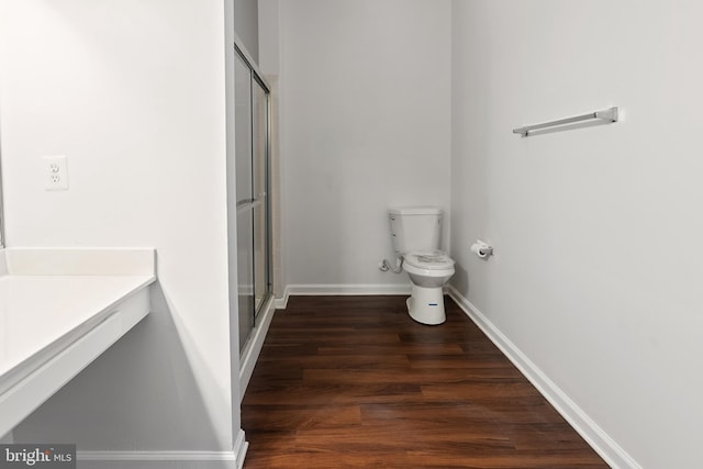 bathroom featuring vanity, wood-type flooring, an enclosed shower, and toilet