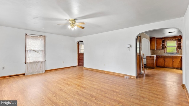 unfurnished living room featuring light wood-type flooring and ceiling fan