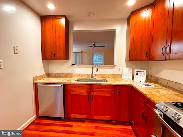 kitchen featuring ceiling fan, sink, stainless steel appliances, and light hardwood / wood-style flooring