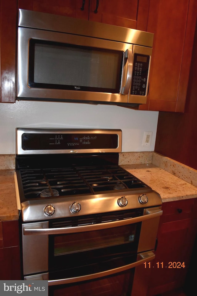 kitchen featuring light stone counters and appliances with stainless steel finishes