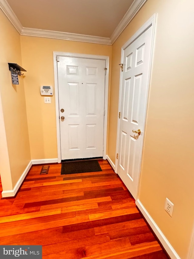 entryway with wood-type flooring and crown molding