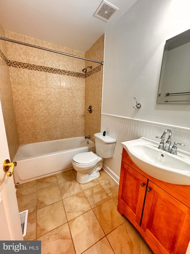 full bathroom featuring tile patterned flooring, vanity, toilet, and tiled shower / bath combo