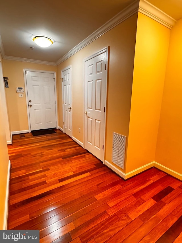 hallway featuring wood-type flooring and crown molding