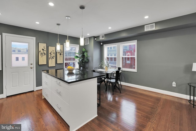 kitchen with hanging light fixtures, dark hardwood / wood-style flooring, white cabinetry, and plenty of natural light