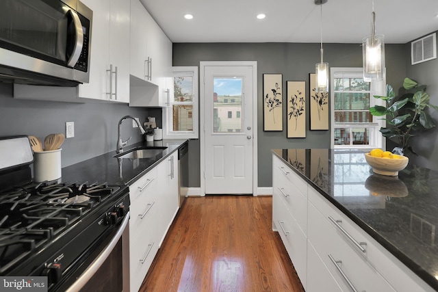 kitchen featuring stainless steel appliances, white cabinetry, and a healthy amount of sunlight