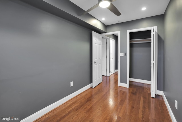 unfurnished bedroom featuring a closet, dark hardwood / wood-style floors, and ceiling fan