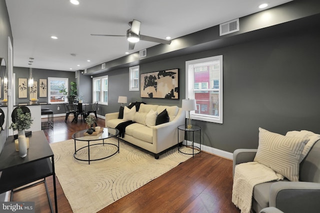 living room with ceiling fan and dark wood-type flooring