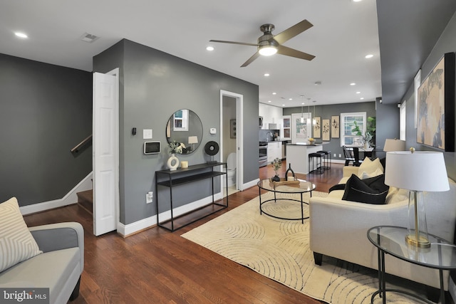 living room with dark hardwood / wood-style floors and ceiling fan