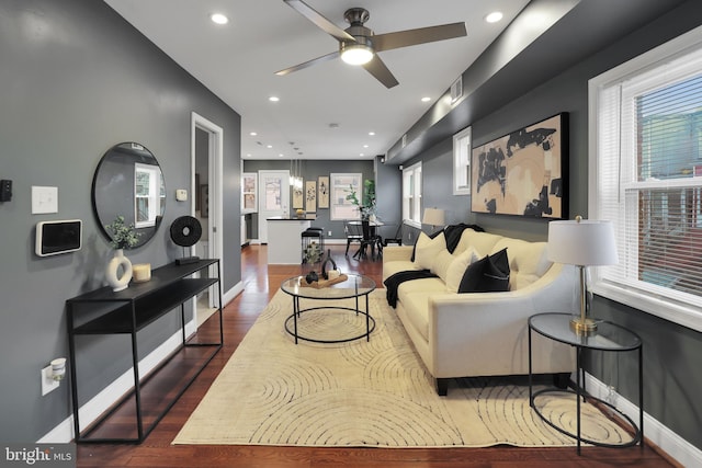 living room with dark hardwood / wood-style flooring and ceiling fan