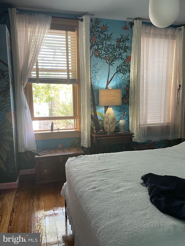 bedroom with hardwood / wood-style floors and multiple windows