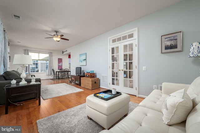 living room with hardwood / wood-style floors, ceiling fan, and french doors