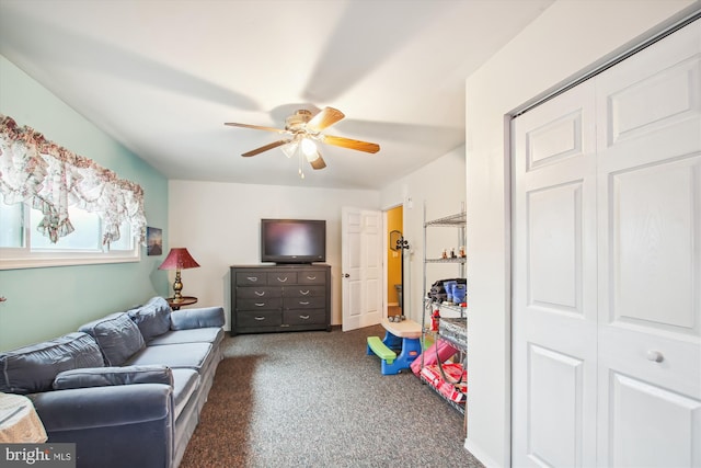 recreation room with ceiling fan and dark carpet