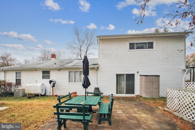682 Duvall Hwy, Pasadena, MD 21122 - back of house with heating fuel, a patio area, central AC unit, and a chimney