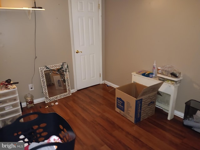 miscellaneous room with heating unit and dark wood-type flooring