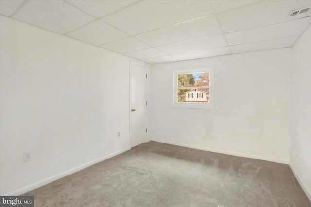 carpeted empty room featuring a paneled ceiling