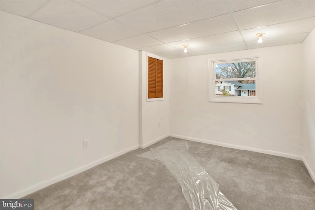 carpeted empty room with a paneled ceiling