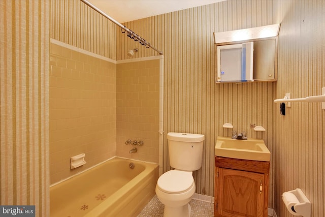 full bathroom featuring tile patterned floors, vanity, tiled shower / bath combo, and toilet