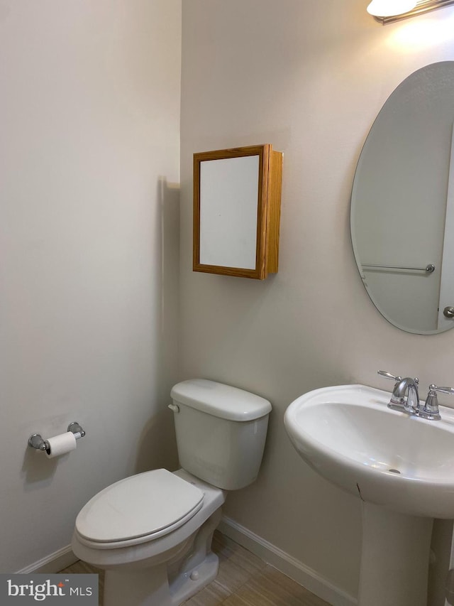 bathroom with hardwood / wood-style floors, toilet, and sink