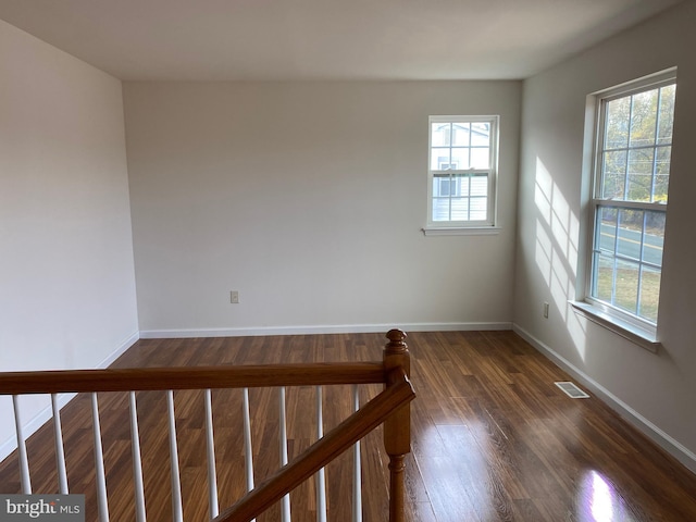 unfurnished room with a wealth of natural light and dark wood-type flooring