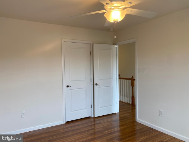 unfurnished bedroom featuring dark hardwood / wood-style flooring and ceiling fan