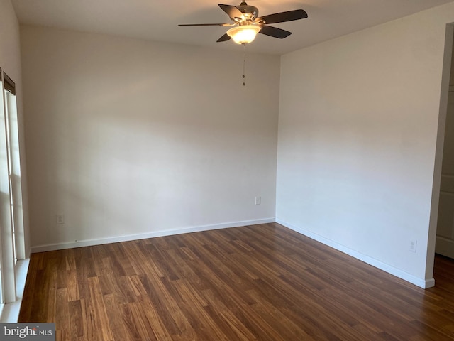 spare room featuring ceiling fan and dark wood-type flooring