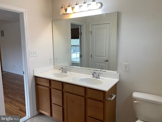 bathroom featuring wood-type flooring, vanity, and toilet