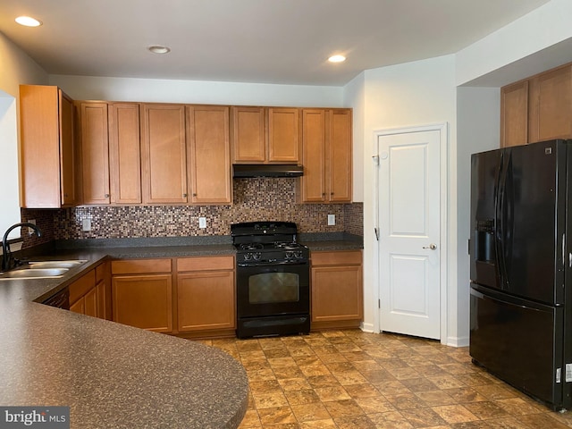 kitchen with black appliances, backsplash, and sink