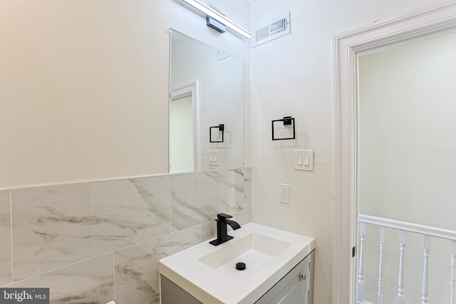 bathroom with vanity and tile walls