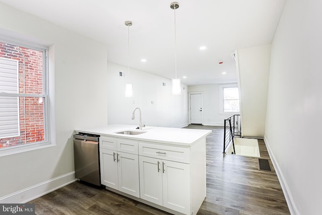 kitchen featuring white cabinetry, dishwasher, sink, dark wood-type flooring, and pendant lighting