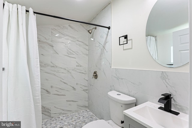 bathroom with a shower with curtain, vanity, toilet, and tile walls