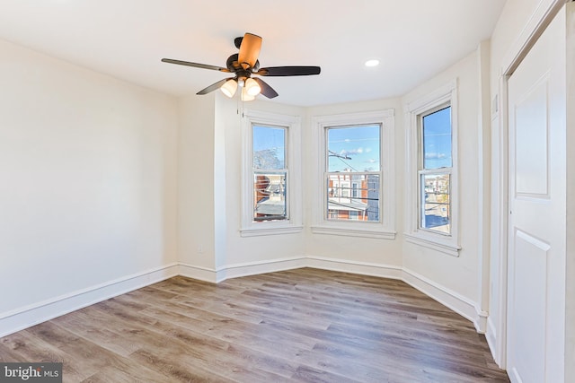 spare room with ceiling fan and light wood-type flooring