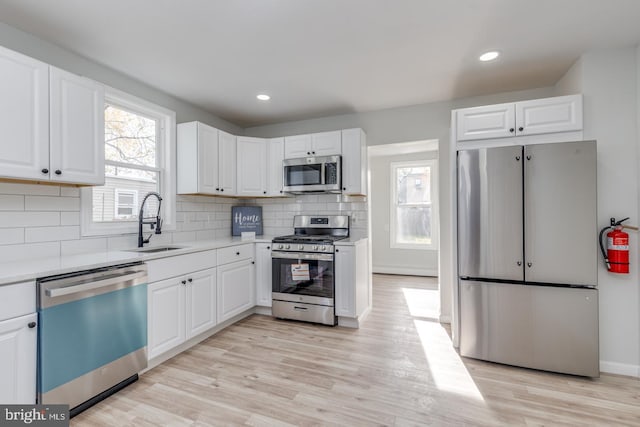 kitchen featuring appliances with stainless steel finishes, white cabinetry, and sink