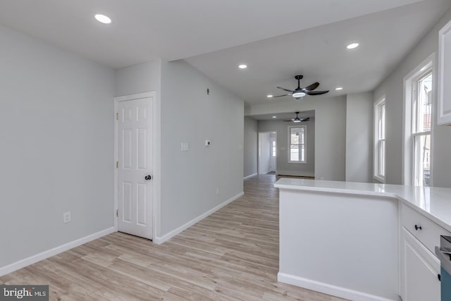 kitchen featuring ceiling fan, white cabinets, and light hardwood / wood-style floors