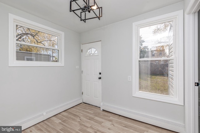 entryway featuring a chandelier, a baseboard radiator, and light wood-type flooring