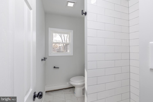 bathroom featuring a tile shower, toilet, and baseboard heating