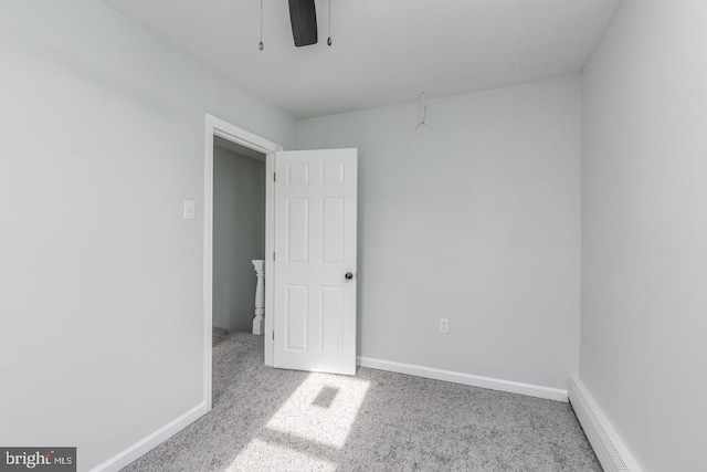 unfurnished room with baseboard heating and light carpet