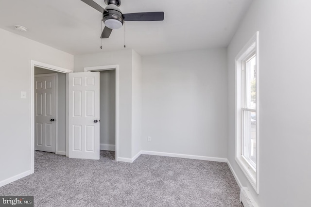 unfurnished bedroom featuring multiple windows, ceiling fan, and light carpet