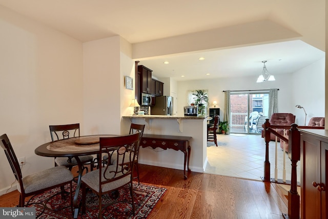 dining room with light hardwood / wood-style floors and a chandelier