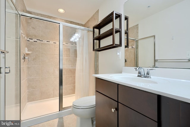 bathroom with tiled shower, tile patterned floors, vanity, and toilet