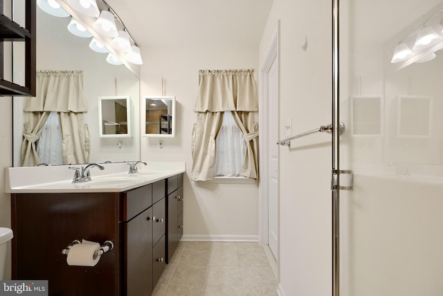 bathroom with tile patterned flooring, vanity, and a shower with door