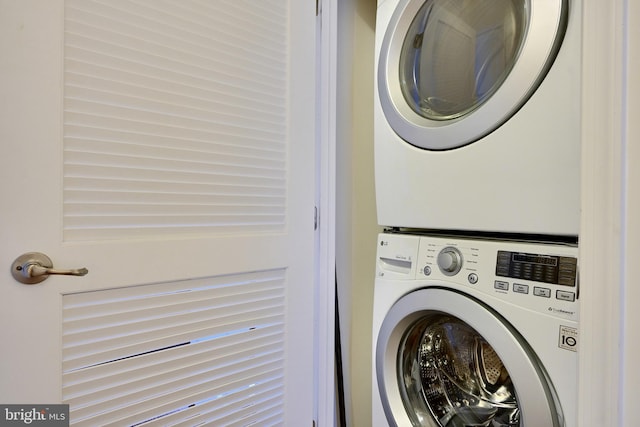 washroom with stacked washing maching and dryer