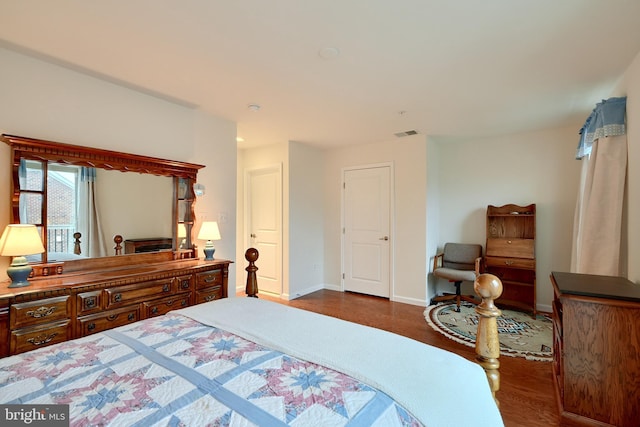 bedroom with dark hardwood / wood-style floors