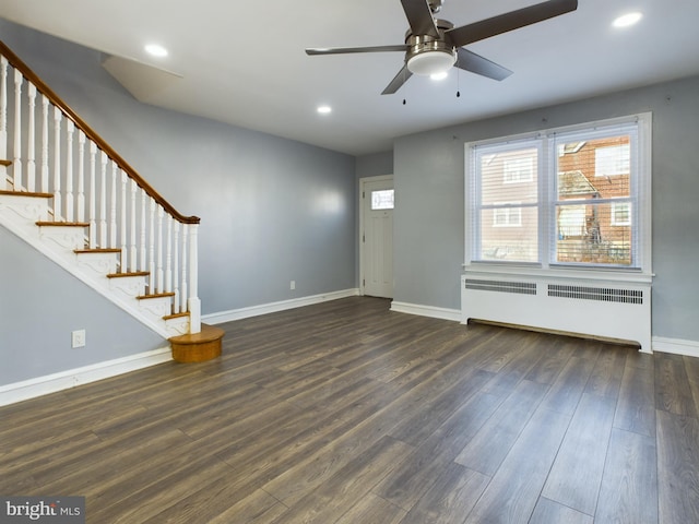 unfurnished living room featuring dark hardwood / wood-style floors, ceiling fan, and radiator