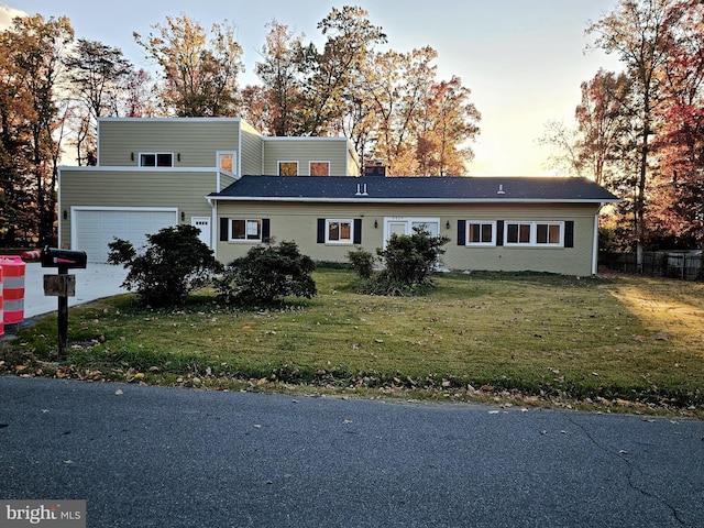 view of front of property with a garage and a yard