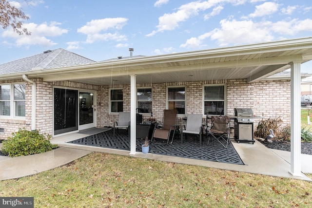 rear view of property with a lawn and a patio