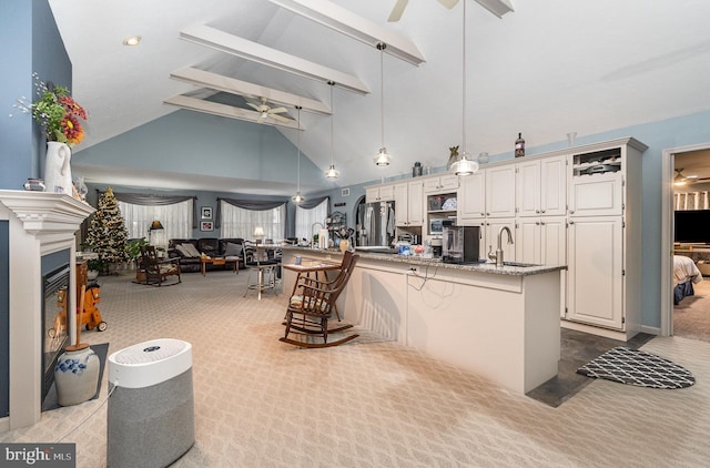 kitchen with decorative light fixtures, stainless steel fridge, light colored carpet, and a breakfast bar area