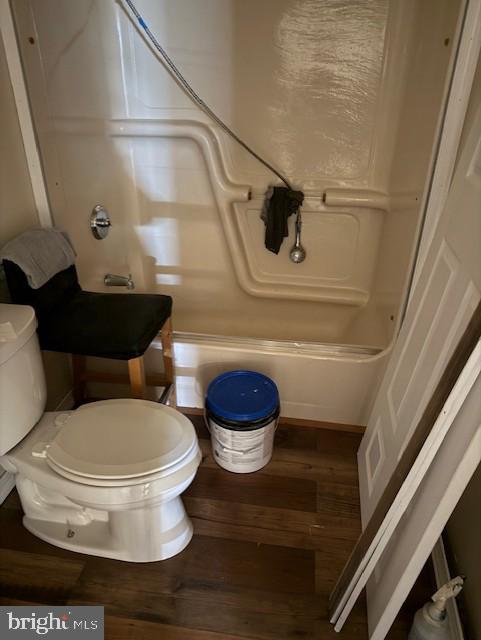 bathroom featuring shower / bath combination, toilet, and wood finished floors