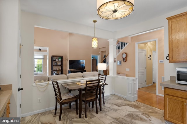 dining area featuring ornate columns and light wood-type flooring