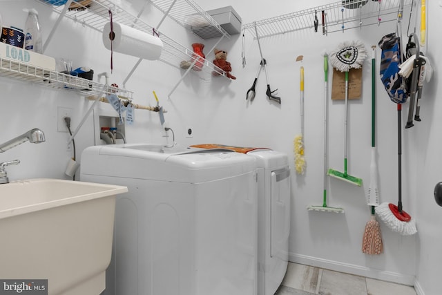 clothes washing area with sink and independent washer and dryer