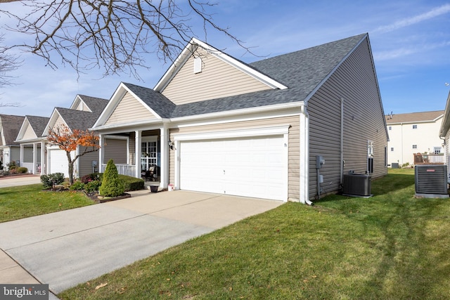 view of front of house with a front yard, a porch, a garage, and central air condition unit